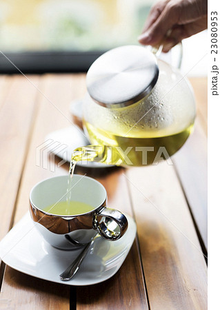 Tea pouring to teacup on table 23080953