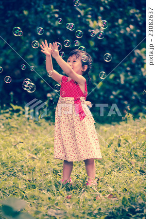 Asian girl catches soap bubbles on nature. Asian girl catches soap bubbles on nature. 23082637