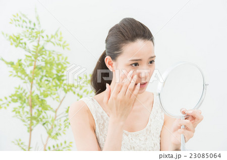 鏡を見る女性（目元ケア　20代) 23085064