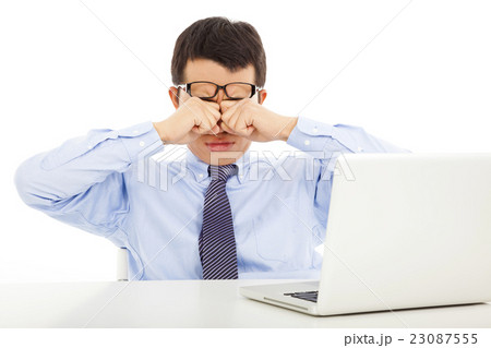tired young businessman rubbing his eyes tired young businessman rubbing his eyes 23087555