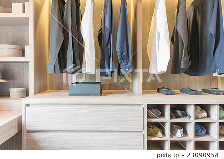 clothes hanging in wooden walk in closet 23090958