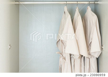 bathrobe hanging on rail in wooden wardrobe 23090959