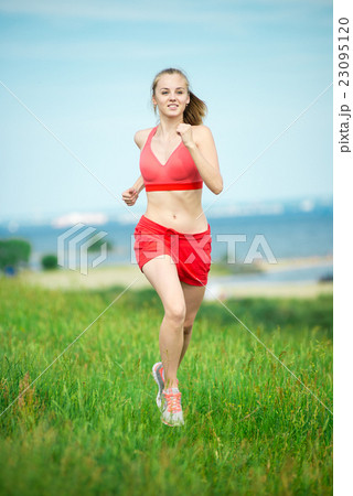 Young woman running summer park rural road 23095120