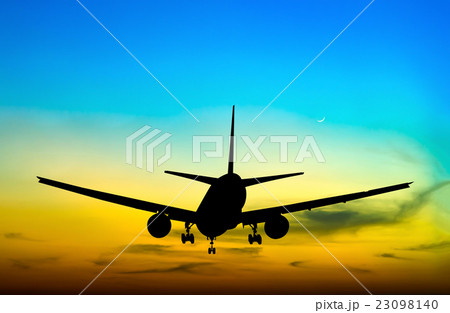 Silhouetted commercial airplane flying at sunset Silhouetted commercial airplane flying at sunset 23098140