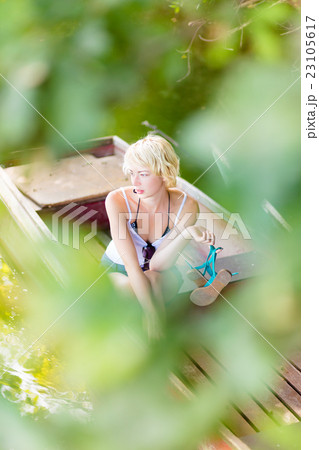 Woman relaxing on the vintage wooden boat. Woman relaxing on the vintage wooden boat. 23105617