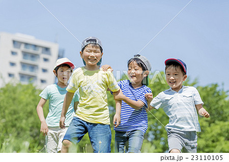 新緑の公園で遊ぶ小学生たちの写真素材