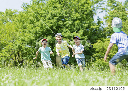 新緑の公園で遊ぶ小学生たちの写真素材