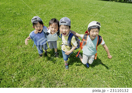 新緑の公園で遊ぶ小学生たちの写真素材