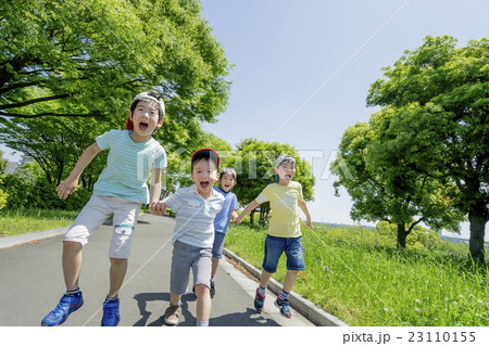 新緑の公園で遊ぶ小学生たちの写真素材