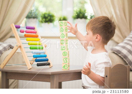 Little boy playing with abacus toy indoors Little boy playing with abacus toy indoors 23113580