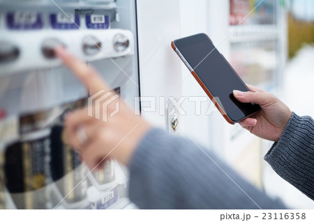 Woman use of soft drink vending system paying by cellphone 23116358