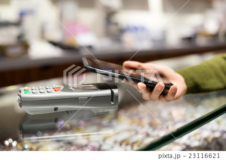 Woman pay by mobile phone with NFC Woman pay by mobile phone with NFC 23116621