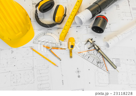 Construction plans with yellow helmet and drawing tools on blueprints . Construction plans with yellow helmet and drawing tools on blueprints . 23118228