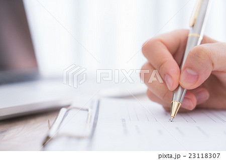 Hand with pen over application form.. Hand with pen over application form.. 23118307