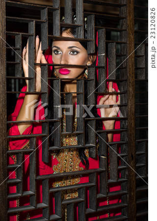 woman standing behind the wooden grid. woman standing behind the wooden grid. 23120826