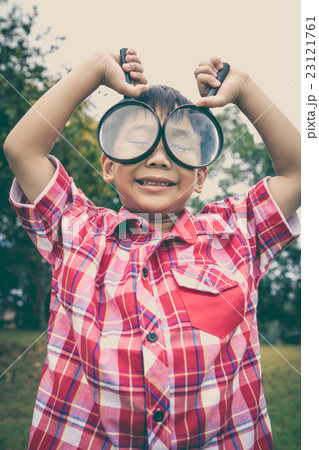 Young boy exploring nature with magnifying glass. Young boy exploring nature with magnifying glass. 23121761