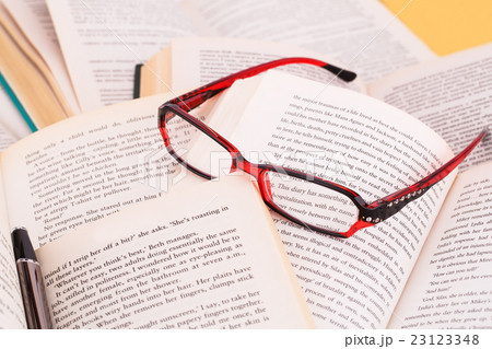 Opened books, eyeglasses and pen Opened books, eyeglasses and pen 23123348