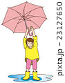 傘を振り上げて雨が降り止んだことを喜ぶ小学生の女の子(レインコート+水溜まり） 23127650