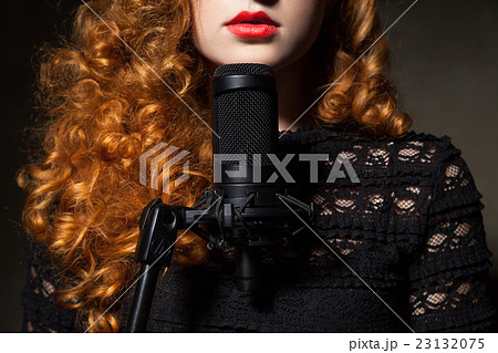 Close-up of curly-haired woman with mic 23132075