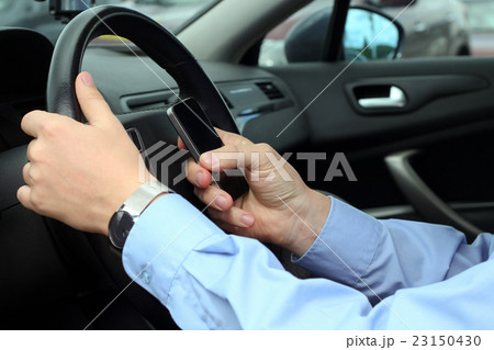 businessman using mobile phone while driving businessman using mobile phone while driving 23150430