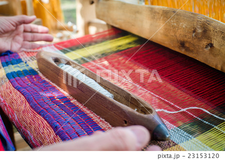 Weaving on a wooden loom 23153120