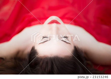 Lady in Red Dress Laying Down Eyes Closed  23153246