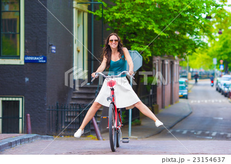 Young happy woman on bike in european city Young happy woman on bike in european city 23154637