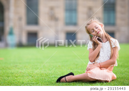 Adorable toddler girl with phone in Paris during Adorable toddler girl with phone in Paris during 23155443