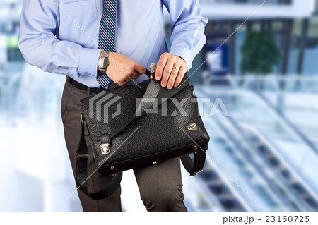 Businessman holding and opening a briefcase Businessman holding and opening a briefcase 23160725
