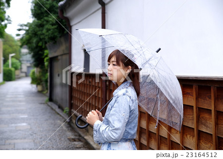 雨傘を差す女性 雨の季節の日本の佇まい 白壁と板張りと石畳 23164512