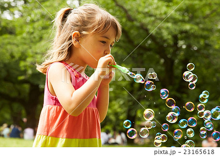 シャボン玉で遊ぶ子供の写真素材