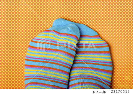someone rubbing his or her feet wit colorful socks someone rubbing his or her feet wit colorful socks 23170515