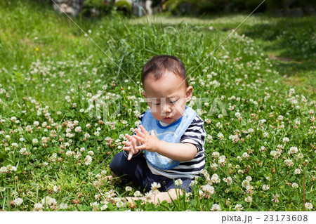 公園でシャボン玉で遊ぶ赤ちゃんの写真素材