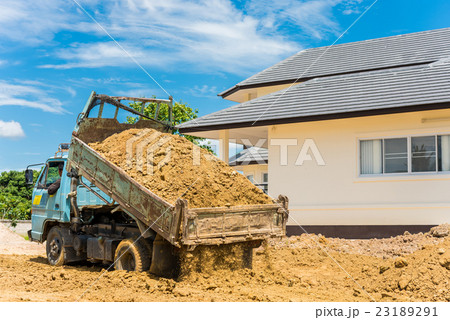 Dump truck unloading soil at construction site 23189291