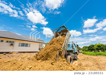 Dump truck unloading soil at construction site 23189331