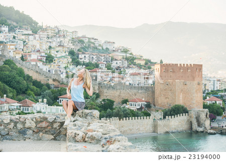 Young blond woman tourist sitting on ancient 23194000