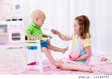 Little girl feeding baby brother 23194595