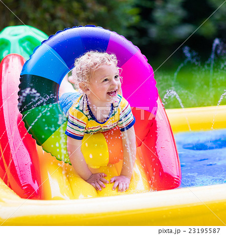 Little boy playing in garden swimming pool Little boy playing in garden swimming pool 23195587