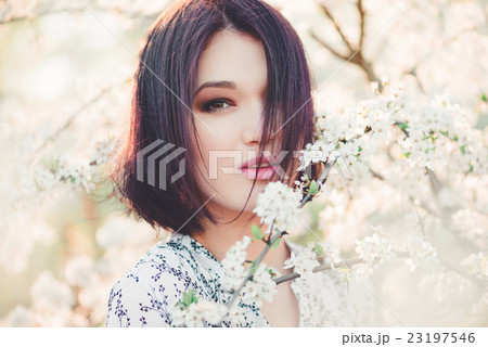 Beautiful young woman in blooming sakura Beautiful young woman in blooming sakura 23197546