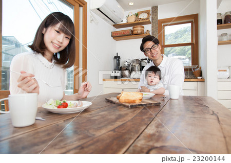 ダイニングテーブルで食事をする家族の写真素材