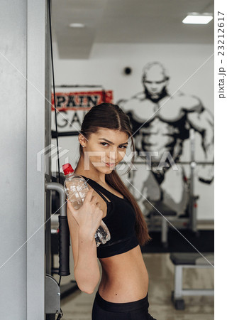 Beautiful girl with water at the gym Beautiful girl with water at the gym 23212617