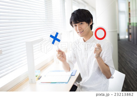 窓際でマルバツサインを持って 23213862