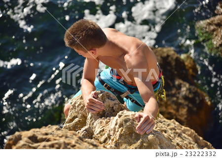 Male climber climbs on rocky wall 23222332