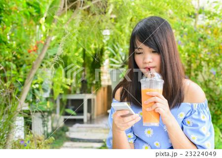 Woman typing text message on smart phone in a cafe 23224049