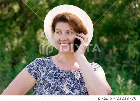 woman in hat talking on cell phone outside 23233770