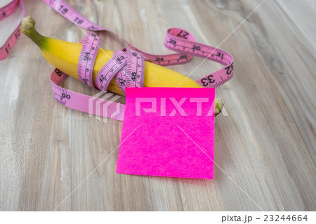 Banana with Sticky Note on wood table . Banana with Sticky Note on wood table . 23244664