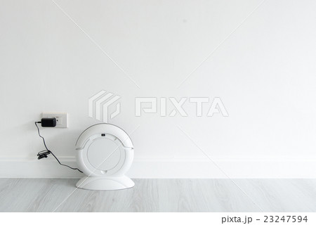 Cleaning robot charging at white wall 23247594