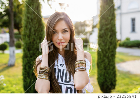 Beautiful young brunette girl posing in a city Beautiful young brunette girl posing in a city 23255841