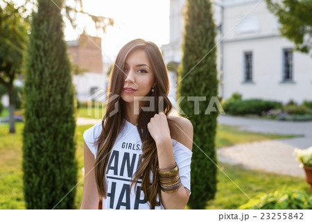 Beautiful young brunette girl posing in a city Beautiful young brunette girl posing in a city 23255842