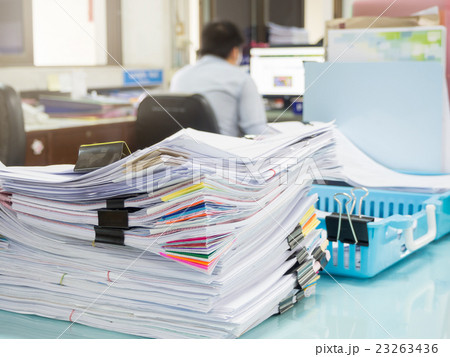 Pile of unfinished paperwork on office desk Pile of unfinished paperwork on office desk 23263436